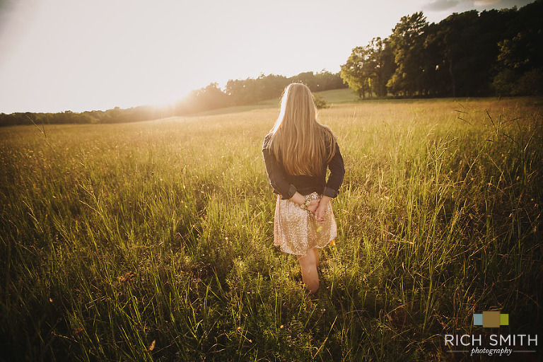 Casey with her back to the camera in a large field during her senior session at the Chickamauga Battlefield near Chattanooga