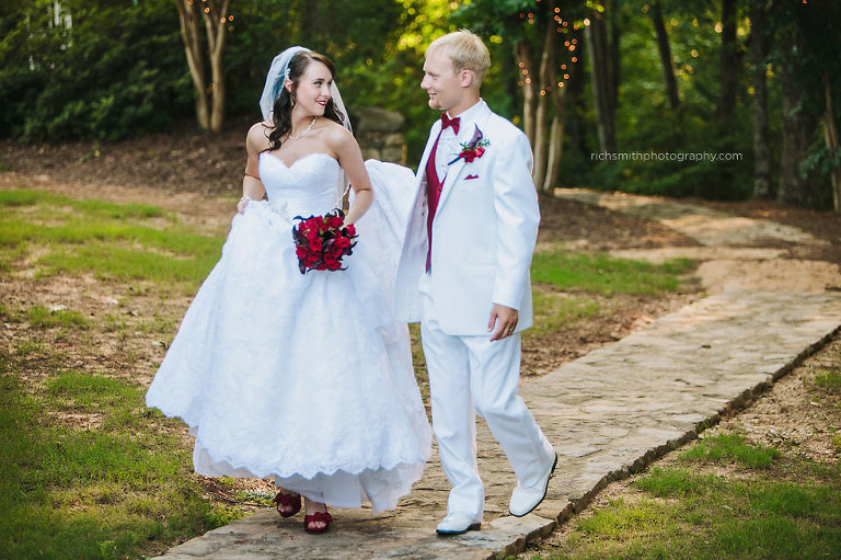 Bride and groom walks down a path at Mountain View Gardens and Ballroom