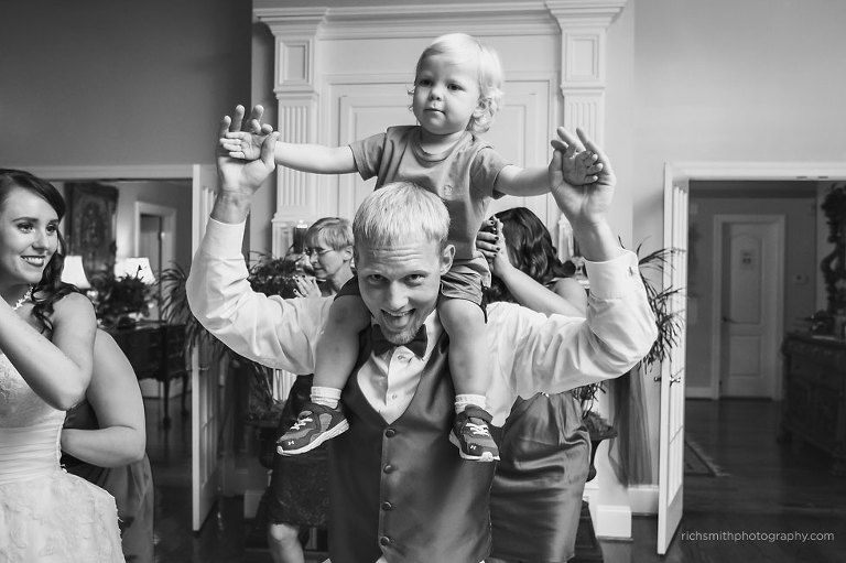 Groom puts his nephew on his shoulders during his reception on the dance floor.