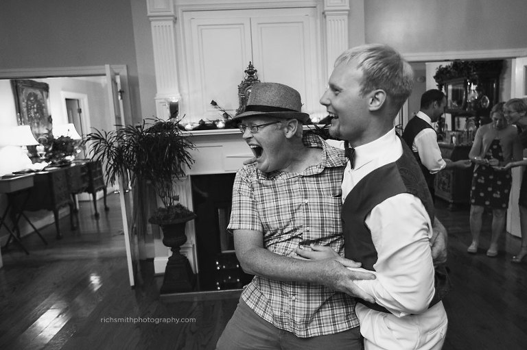 Wedding guest has fun with the groom on his wedding day.