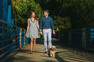Alex and Kevin walking their dog over a bridge