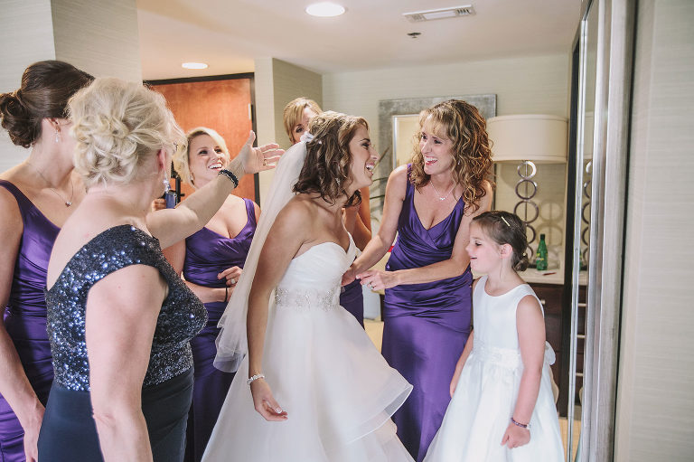 bride with her mom and bridesmaids getting ready for her wedding