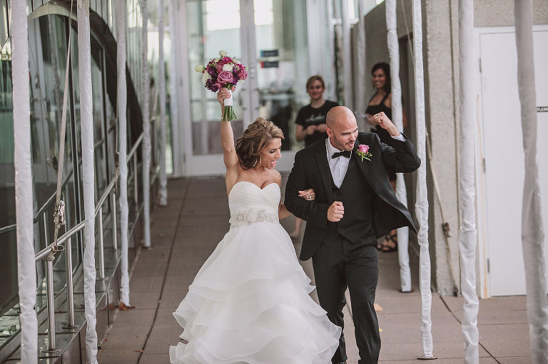 bride and groom excitedly entering their reception