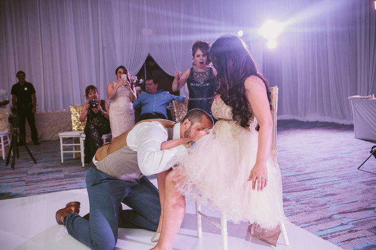 groom taking off brides garter 