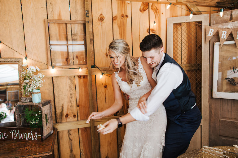 bride and groom cut wedding cake