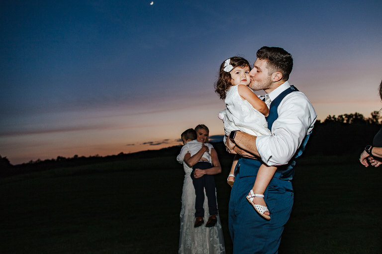 groom kissing flower girl 