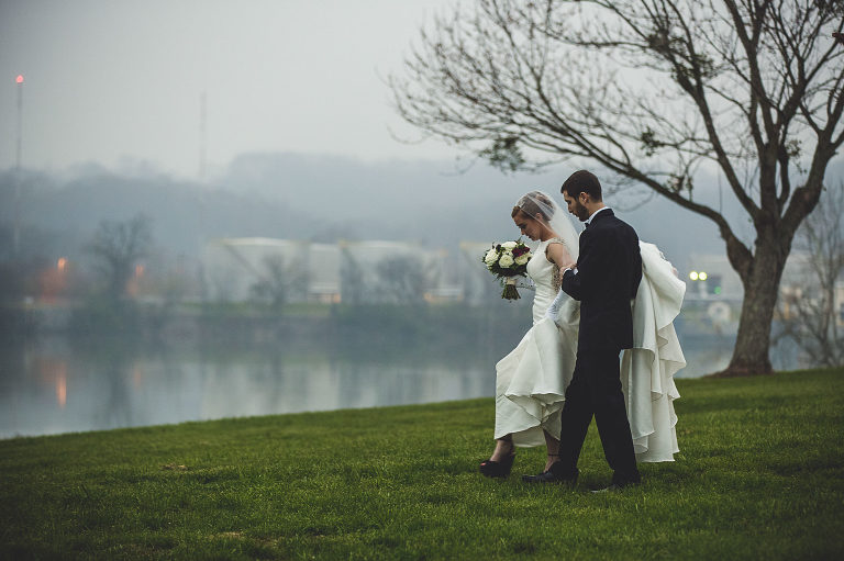bride and groom walking on a rainy day