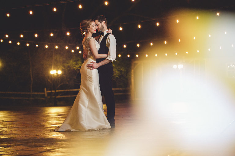 bride and groom at night with patio lights 