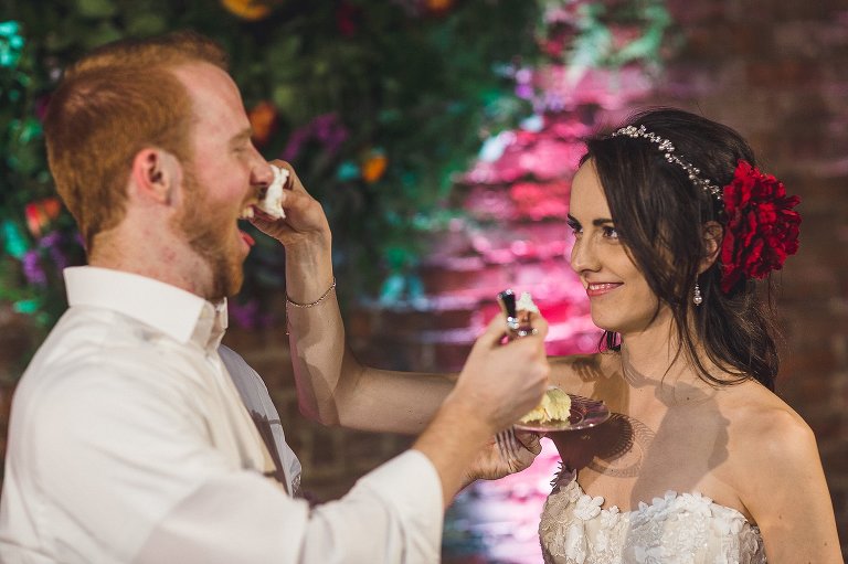 bride and groom feeding each other cake 