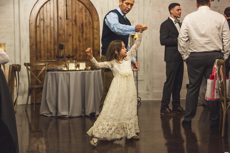 little girl dances with her father during reception