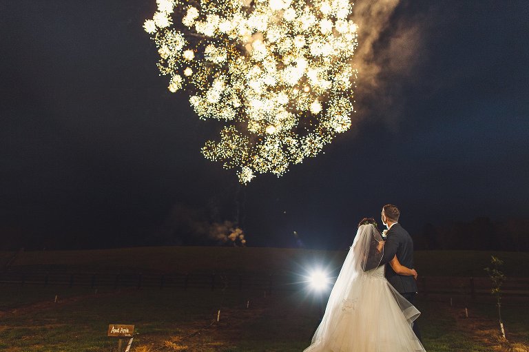 bride and groom watch fireworks after their reception