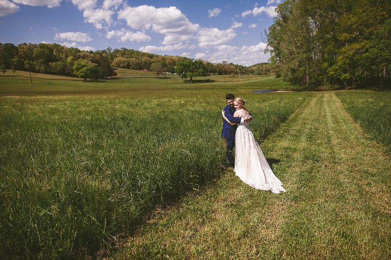 bride and groom embrace on beautiful property 