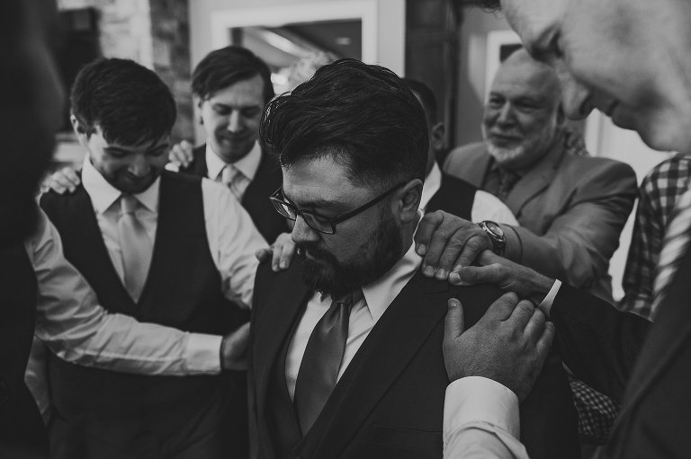 groom and men praying 