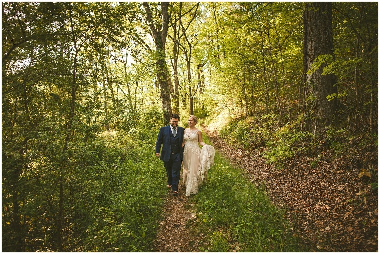 bride and groom walking in forest 