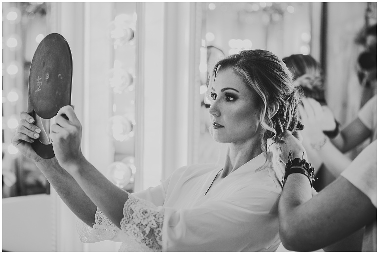 bride looking in mirror at her hair