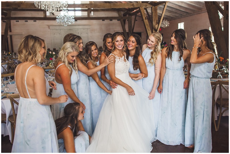 bride with bridesmaids laughing 