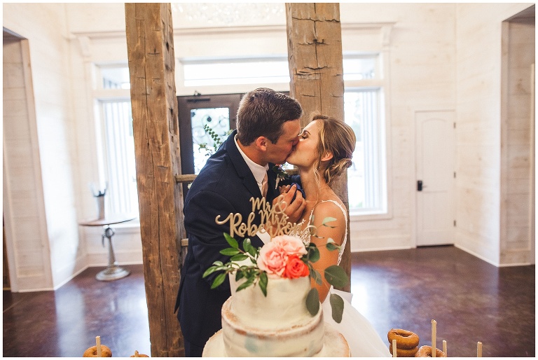 bride and groom kiss at cake cutting 