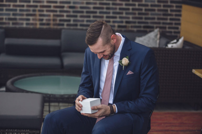groom opening gift from bride