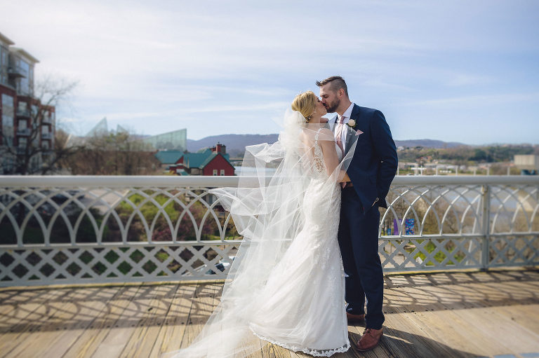 bride and groom kiss on walking bridge chattanooga