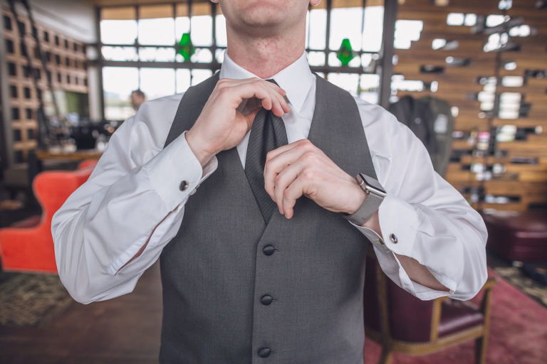 groom getting ready and straightening his tie