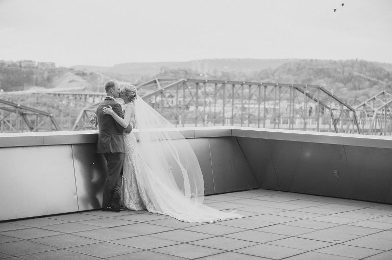 bride and groom kiss on veranda at hunter museum 