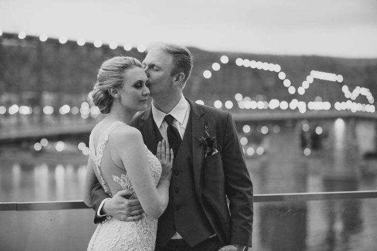 Groom kissing his bride on forehead