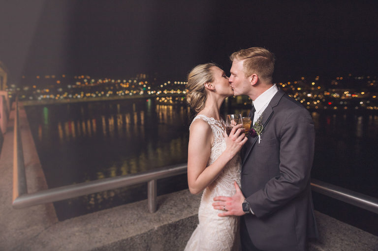 bride and groom kissing at dark on the veranda of the hunter museum 